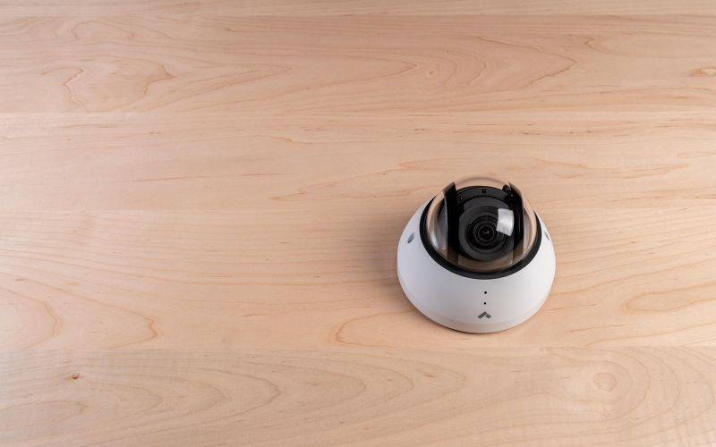 Dome security camera mounted on a wood-paneled ceiling