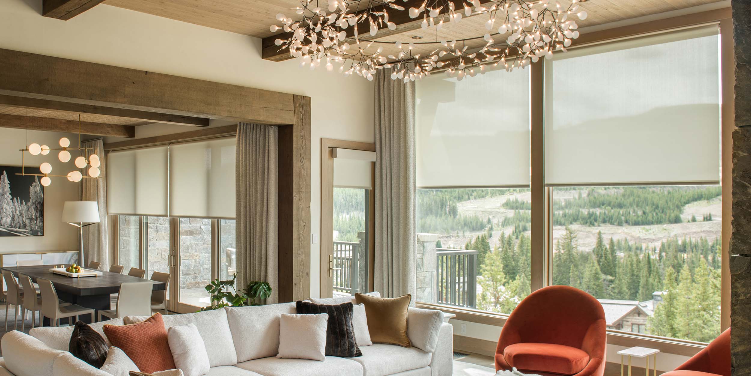 Rustic living room with Lutron roller shades and automated drapery.