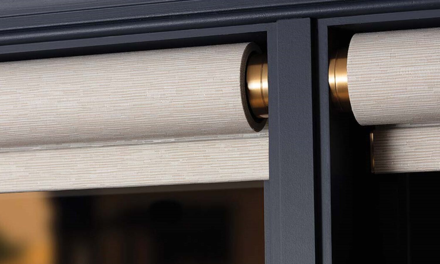 Close-up of Lutron Palladiom exposed roller shade brackets in brass.